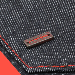 Custom logo badge trim applied to denim fabric