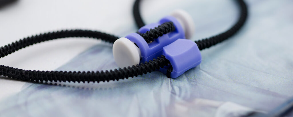 Cord stoppers for apparel manufacturers and adjustable drawcord systems