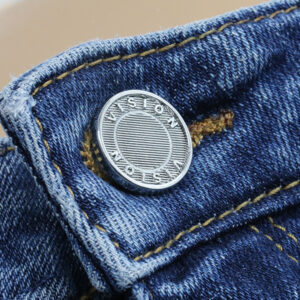 Custom jeans button applied on denim waistband for garment finishing